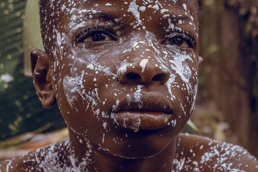 young boy with white paint splatters across his face
